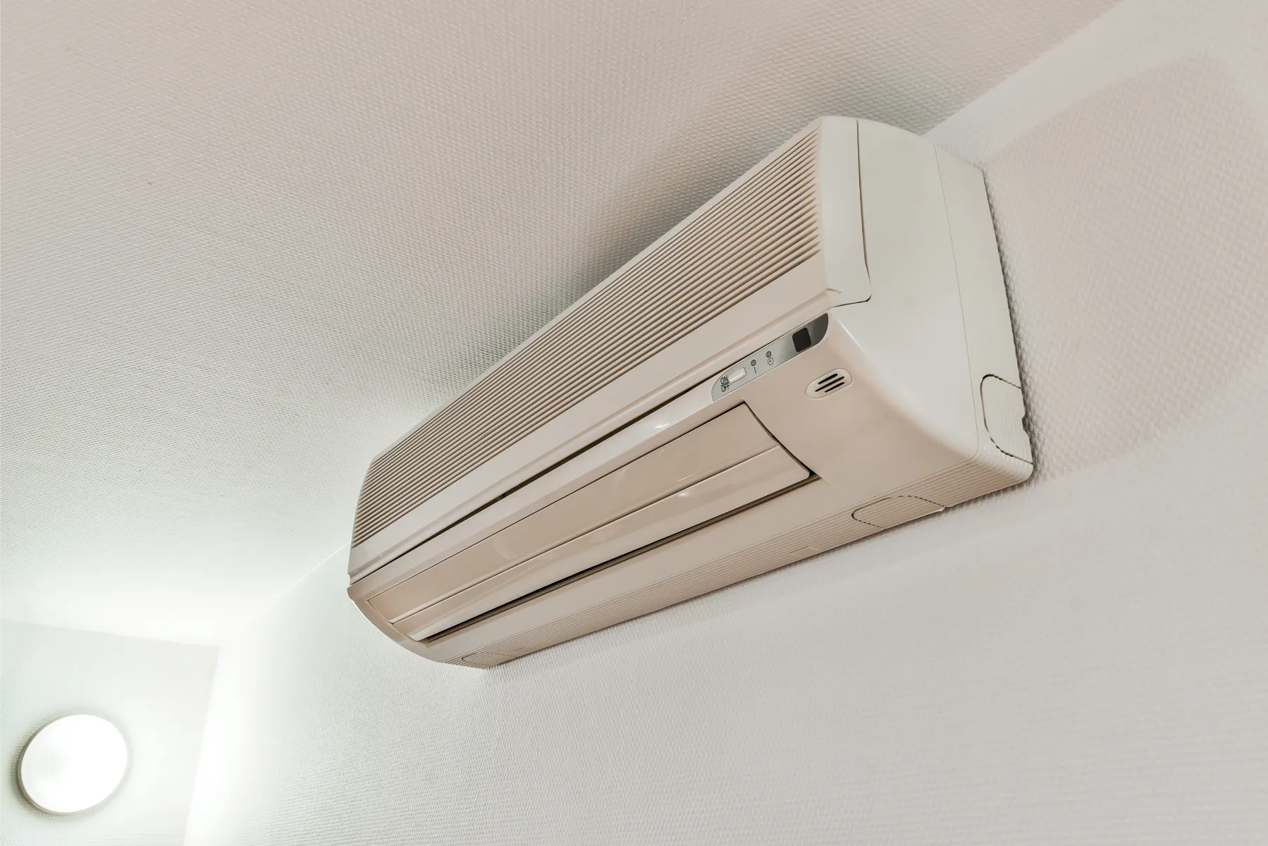 Biała jednostka wewnętrzna klimatyzatora zainstalowana pod sufitem